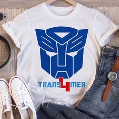 a t - shirt that says,'transformer + plus'next to some shoes