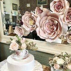 there is a white cake with pink flowers on it and a mirror in the background