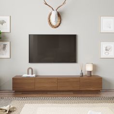 a flat screen tv mounted to the side of a wooden cabinet in a living room