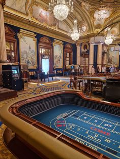 a casino table in the middle of a room with chandeliers