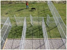 an aerial view of a man and his dog walking in the grass with their caged enclosures