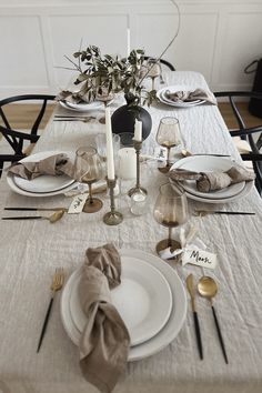 the table is set with white plates and silverware