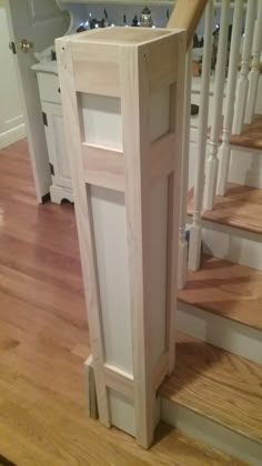 a wooden stair case sitting on top of a hard wood floor next to a banister