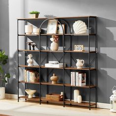 a book shelf with books, vases and other items on it in a living room