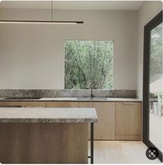 an empty kitchen with marble counter tops and wooden cabinets, along with sliding glass doors