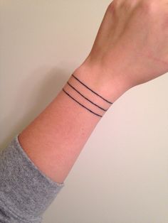 a woman's wrist with three thin lines on it