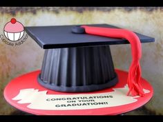 a graduation cake with a red tassel on it's top and the words congratulations