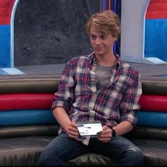 a young man sitting on top of an inflatable couch holding a piece of paper