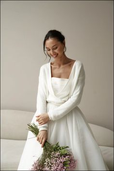 a woman in a white dress holding flowers