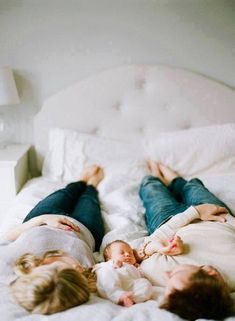 two people laying on top of a bed next to each other