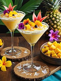 two glasses filled with fruit and garnish sitting on top of a wooden table