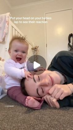 a woman laying on the floor with a baby in her lap and an adult holding it up to her face