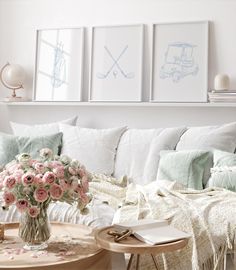 a living room filled with lots of furniture and flowers on top of a coffee table