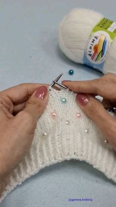 someone is knitting something with scissors on the table