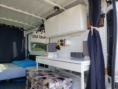 the inside of a camper with a bed and desk