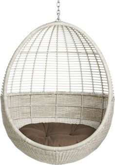 the hanging egg chair is made from wicker and has an oval shape, with a white