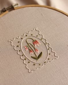 a close up of a embroidery on a piece of cloth with flowers in the center