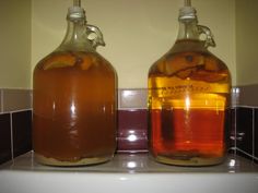 two bottles filled with liquid sitting on top of a counter