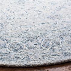 a blue rug with an intricate design on the top and bottom is laying on a wooden floor