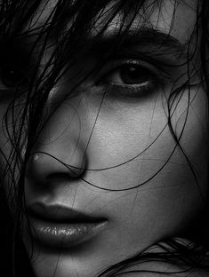 a woman's face with long hair blowing in the wind, black and white photograph