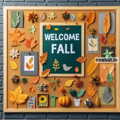 a welcome fall sign surrounded by autumn leaves and paper cut outs on a brick wall