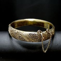 *Description: This is a beautiful Art Nouveau hinged silver bracelet with a gold wash from around the 1920s. It has European origins with stamps for silver and one difficult to read on the clasp. Photo is included. This silver bracelet with a gold wash was tested by me and tested for silver and minimum 10K gold wash or vermeil. The clasp and hinge are in great working order. If you are looking for a wonderful heirloom gift, this would be perfect. This bracelet would be a great addition to your v Antique 14k Stamped Bangle As Gift, Vintage Yellow Gold Bangle Stamped 14k, Antique Gold Bracelet Stamped 14k, Antique 14k Stamped Gold Bracelet, Vintage 14k Stamped Yellow Gold Bangle, Antique Hallmarked Yellow Gold Bangle, Antique Yellow Gold Hallmarked Bangle, Antique Stamped 14k Bangle Bracelet, Vintage 14k Gold Hallmarked Bangle