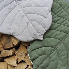 a pile of wood sitting next to a green and white blanket on top of it