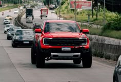 the red truck is driving down the road with other cars on it's side