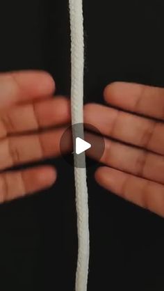 two hands holding white rope in front of each other