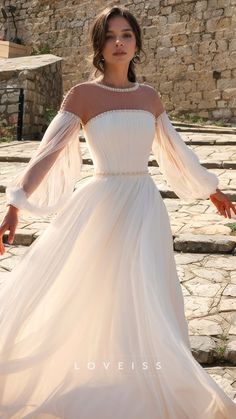 a woman in a white dress is standing on some steps and posing for the camera