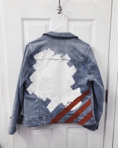 a jacket hanging on a door with paint splattered on the back and sides