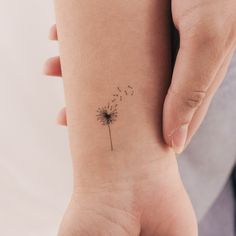 a small dandelion tattoo on the wrist