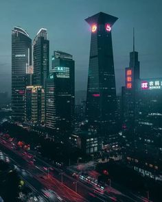 an aerial view of a city at night with lights and skyscrapers in the background