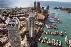 an aerial view of a city with boats in the water and high rise buildings on both sides