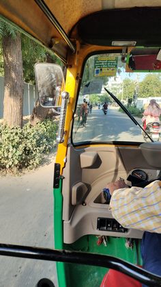 a man driving a green truck down a street