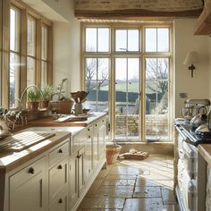 a large kitchen with lots of counter space and wooden beams on the ceiling, along with an open window