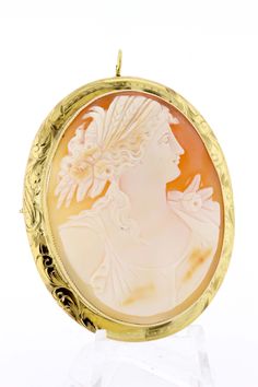 This delightful cameo brooch is made in 14K yellow gold and oval cut cut piece with a Greek motif with a female figure. She's detailed with braided hair, feathers, and roses. The brooch is accented with an engraved bezel and migraine edge. It can also be worn as a necklace too--has a toggle that can flip up or down. The entire piece measures 57mm long, 46.31mm wide, 11.33mm tall, and weighs 10.7DWT. B55KIPPN --Please reference our policy for more details before purchase-- For International order Luxury Oval Cameo Brooch, Yellow Gold Oval Cameo Brooch, Luxury Oval Intaglio Brooches, Luxury Oval Engraved Brooches, Convertible Necklace, Carved Shell, Cameo Brooch, Gold Hands, Hand Engraving