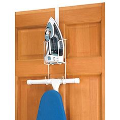 an ironing board is hanging on the wall next to a wooden door and a blue iron