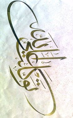 an arabic calligraphy written in gold on a white paper with black writing and green ink