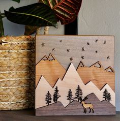 a wooden card with an image of a deer in the mountains