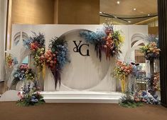 a decorated stage with flowers and greenery in front of a large sign that says y