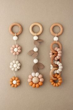 three wooden beads hanging from the side of each beaded necklace on a beige background