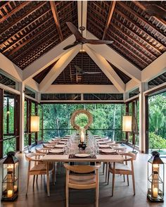 a large dining room with wooden tables and chairs in front of an open air ceiling