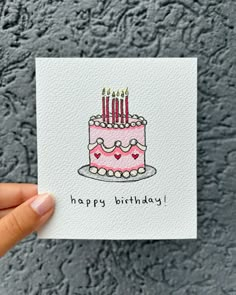 a hand holding up a card with a birthday cake on it