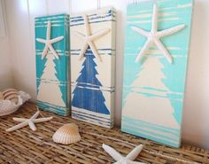 three wooden boards with starfish and christmas trees painted on them