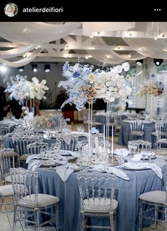 the tables are set up with blue linens and white flowers