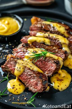 steak with mustard sauce on a black plate