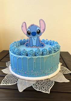 a blue cake decorated with an image of a baby elephant on it's top