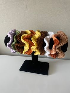 four crocheted scrunffles sitting on top of a black stand