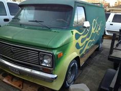 an old green van with flames painted on it's front and back bumpers